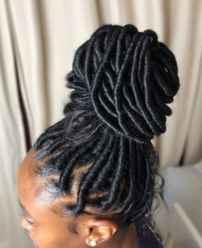 A lady with faux locs in a bun