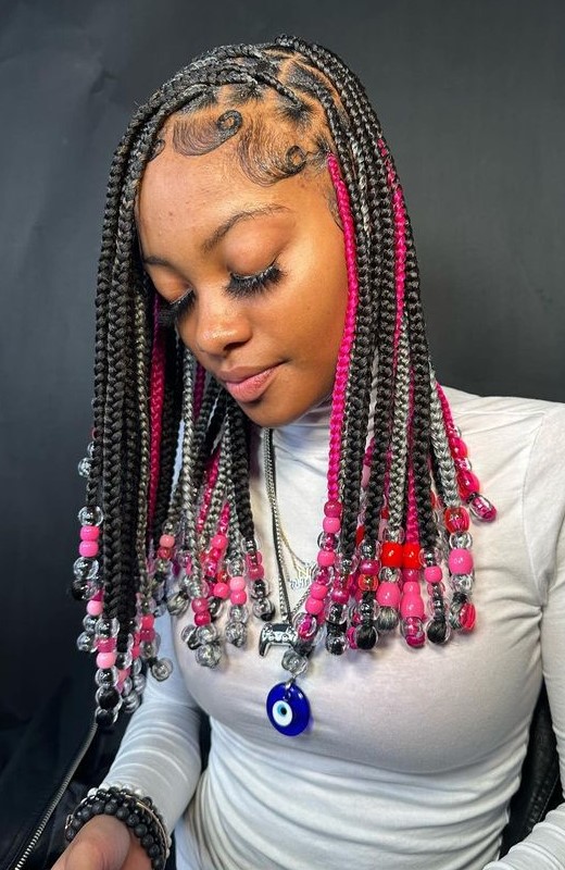 A lady with pink peekaboo braids with beads